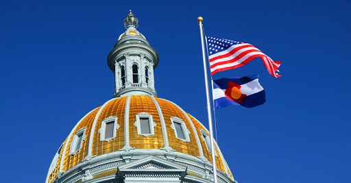 the top of the colorado state capital with the US and CO flag flying